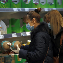 Dos mujeres con mascarilla y guantes se abastecen en un supermercado en Bilbao. EFE/LUIS TEJIDO