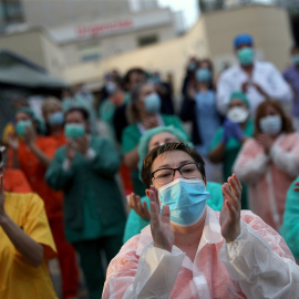 Personal sanitario del Hospital Gregorio Marañón de Madrid responde a los aplausos del vecindario, que agradece su trabajo durante la pandemia del coronavirus. REUTERS/Susana Vera
