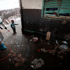 Un niño observa a un miembro de los servicios locales de higiene, con traje de protección y mascarilla, mientras desinfecta una escuela escuela coránica, en Dakar, Senegal. REUTERS / Zohra Bensemra