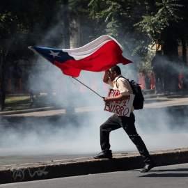 Un manifestante ondea la bandera chilena durante choques con efectivos policiales frente al Palacio de La Moneda, sede del Gobierno en Santiago (Chile).. EFE/Fernando Bizerra Jr.