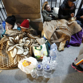 Solicitantes de asilo que esperan un recurso de acogida frente a las puertas del Samur Social de Madrid. EFE/Javier Lizón