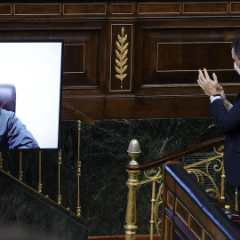  El presidente del Gobierno, Pedro Sánchez (d), aplaude la intervención por videoconferencia del presidente de Ucrania, Volodímir Zelensky (i), durante el pleno del Congreso de los Diputados. - EFE