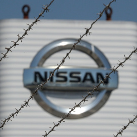 El logo de Nisan, a través de la alambrada que rodea su planta en la Zona Franca de Barcelona. REUTERS/ Albert Gea