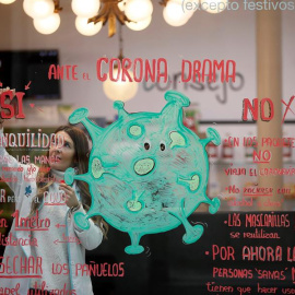 Noelia, trabajadora y autora de la obra gráfica en el escaparate de la farmacia La Salud de Lugo, cuyo leit motiv es el coronavirus. EFE/ Eliseo Trigo
