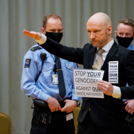 Anders Behring Breivik levanta el brazo para hacer un saludo nazi cuando llega el primer día del juicio donde solicita la libertad condicional, el 18 de enero de 2022 en una sala de audiencias improvisada en la prisión de Skien, Noruega.- AFP