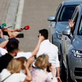  El rey Juan Carlos saluda desde el vehículo a los medios y a las personas congregadas a la entrada del Club Náutico de Sanxenxo (Pontevedra). REUTERS/Pedro Nunes