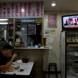 Un hombre almuerza en un restaurante de Taipei, la capital de Taiwan, mientras en la televisión informan sobre la visita de la presidenta de la Cámara de Representantes de EEUU, Nancy Pelosi. REUTERS/Ann Wang