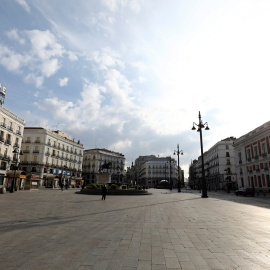 Una mujer, con mascarilla, en una solitaria Puerta de Sol, la céntrica plaza de Madrid, el primer día de semiconfinamiento. REUTERS/Sergio Perez