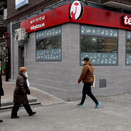 Peatones con mascarilla pasan frente a un restaurante Telepizza en Madrid. EFE/ Kiko Huesca