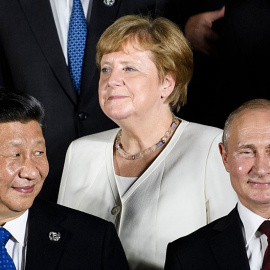  El presidente de China, Xi Jinping (L), la canciller de Alemania, Angela Merkel (C), y el presidente de Rusia, Vladimir Putin, posan para una foto grupal antes de un evento cultural en el Osaka Geihinkan en el Parque del Castillo de Osaka durante la Cumb