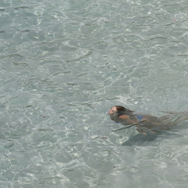 Una mujer nada enla playa de Illetes, en Mallorca. E.P./Clara Margais/dpa