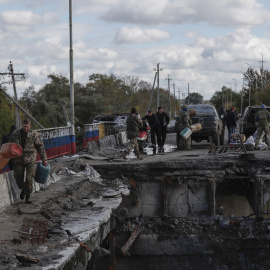 Soldados ucranianos transportan suministros a través de un puente dañado hacia la ciudad recién liberada de Kupiansk, al este de Járkov. EFE/EPA/ATEF SAFADI