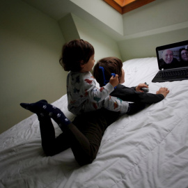  Dos niños conversan con sus abuelos mediante una videollamada en su casa. EFE/Cabalar