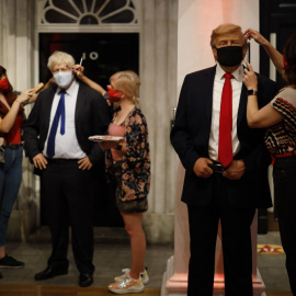  Operarias del Museo Madame Tussauds, de Londres, dan los últimos retoques a las figuras de cera que representan a Boris Jonhnson y a Donald Trump, antes de su reapertura el pasado verano, tras el cierre por la pandemia del coronavirus. AFP/Tolga Akmen