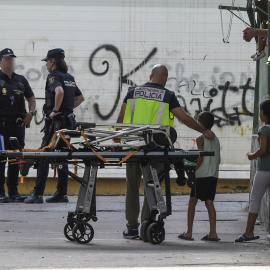 Miembros de la Policía Nacional acompañan a los hijos de una joven asesinada en Almería, presuntamente por su pareja. EFE / Carlos Barba