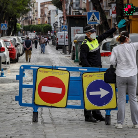 Una mujer consulta a un policía local en una de las calles peatonalizadas del sevillano barrio de Triana, con el fin de evitar las aglomeraciones en las aceras. EFE/José Manuel Vidal