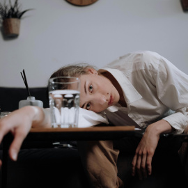  Mujer apoyada en una mesa. Ron Lanch / Pexels