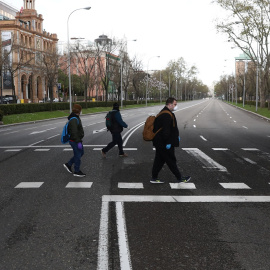  Tres personal con mascarilla cruzan el madrileño Paseo de la Castellana, con las calles prácticamente desérticas. REUTERS/Sergio Perez