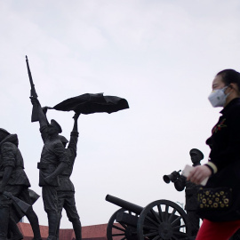 Una mujer con mascarilla pasa por delante del monumento que simboliza la Revolución Xinhai que derrocó al último emperador de China en 1911, en la localidad de Wuhan, el epicentro del coronavirus. REUTERS / Aly Song