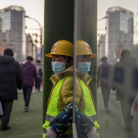 Un trabajador con mascarilla, en el exterior de un edificio en construcción en Pekín (China). REUTERS/Thomas Peter