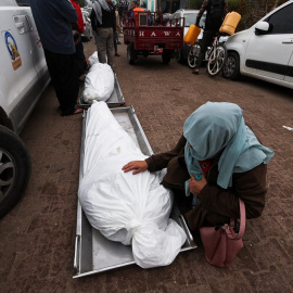  Una mujer frente al cuerpo de un asesinado por Israel en Gaza, a 5 de diciembre de 2023. REUTERS/Ibraheem Abu Mustafa