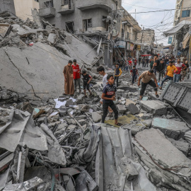  Palestinos caminan entre los escombros de un edificio destruido, tras un ataque aéreo israelí contra Khan Yunis.- Abed Rahim Khatib/dpa