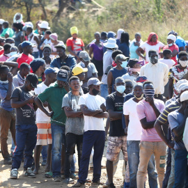 Multitud de personas haciendo cola para recibir ayuda alimentaria, en Sunderland Ridge (Sudáfrica), durante las restricciones impuestas por la pandemia del coronavirus. REUTERS / Siphiwe Sibeko