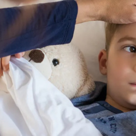 Una madre toma la temperatura a su hijo