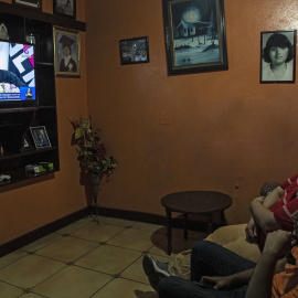 Dos hombres en su casa viendo por televisión la intervención del presidente de Nicaragua, Daniel Ortega, en Managua. AFP/INTI OCON