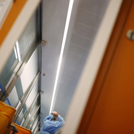 Una trabajadora sanitaria se prepara para atender a un paciente enfermo de covid, en la UCI del Hospital Clinic de Barcelona. REUTERS/Nacho Doce