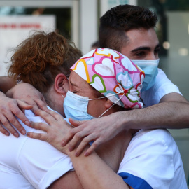 Personal sanitario de la Fundación Jiménez Díaz de Madrid se abraza emocionado ante los aplausos de los vecinos en apoyo al trabajo de la sanidad pública. REUTERS/Sergio Perez