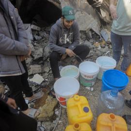  Palestinos recogen agua de una casa destruida cerca del campamento de refugiados de Jabalina en Gaza.- REUTERS/Mahmoud
