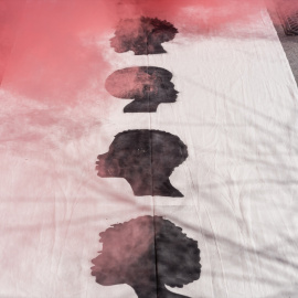 Humo rojo y siluetas negras durante una acción de protesta de la Asamblea Antirracista de Madrid en 2023.- Diego Radamés / Europa Press