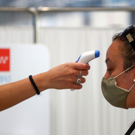Una sanitaria toma la tempreatura a una mujer en un centro de atención primaria de la Comunidad de Madrid. REUTERS/Sergio Perez