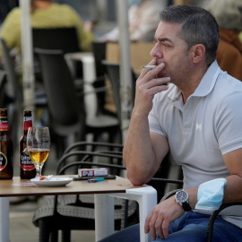 Un hombre fumando en la terraza de un bar en Pontevedra. REUTERS/Miguel Vidal