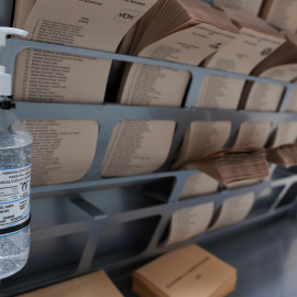 Un dispensador de gel hidroalcohólico junto a las papeletas de votación en un colegio electoral para las elecciones a la Comunidad de Madrid del 4M. REUTERS/Susana Vera