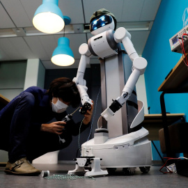 Un técnico de la compañía japonesa Mira Robotics cambia una pieza al robot Ugo. REUTERS/Kim Kyung-Hoon