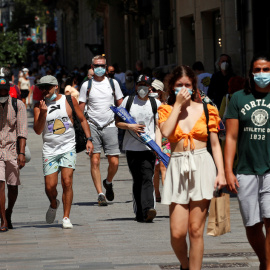 Personas con mascarilla paseando por el centro de Bacelona. REUTERS/Albert Gea