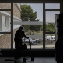 Una residente de un centro de mayores de Madrid camina con un andador. E.P./Eduardo Parra