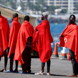 Varios migrantes esperan a ser atendidos por la Cruz Roja tras desembarcar n el puerto de Arguineguin, en Gran Canaria. REUTERS/Borja Suarez