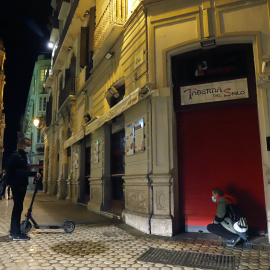  Un camarero cierra el bar ubicado en el centro de Málaga, como consecuencia del toque de queda impuesto por el Gobierno para poder frenar el coronavirus. E.P./Álex Zea