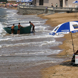 Un agente vigila la zona de la playa de la localidad costera china de Beidaihe reservada para los funcionarios del Gobierno. REUTERS