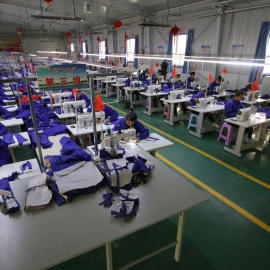 Mujeres uigures en una fábrica textil en la provincia china de Xinjiang. Shutterstock / Azamat Imanaliev