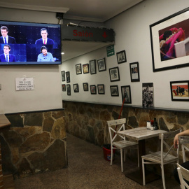 Una mujer observa el debate electoral a cuatro en TVE, en un televisión en un bar en Madrid. REUTERS/Susana Vera