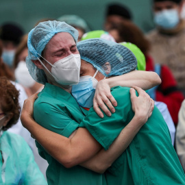 Dos trabajadoras sanitarias se abrazan en una concentración en recuerdo y homenaje a un compañero fallecido por el coronavirus, en el exterior del Hospital Severo Ochoa, en Leganés (Madrid). REUTERS/Susana Vera