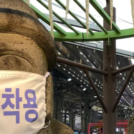  Dos esculturas de piedra con mascarillas con la leyenda Use mascarilla en Jeju, Corea del Sur. Shutterstock / emeskei