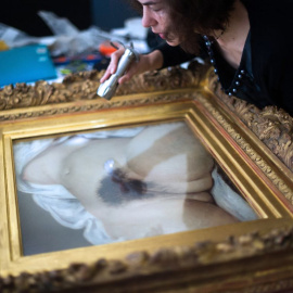  Una mujer examina el lienzo de Gustave Courbet 'El origen del mundo', a 3 de junio de 2014, en Ornans, este de Francia.- AFP