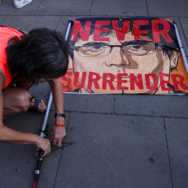 Una simpatizante de Carles Puigdemont prepara una pancarta para recibir al dirigente independentista en su reaparición en Barcelona tras siete años de exilio. — Nacho Doce / REUTERS