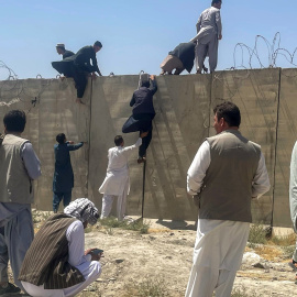 Hombres afganos tratan de entrar en el Aeropuerto de Kabul tras la victoria talibán. REUTERS