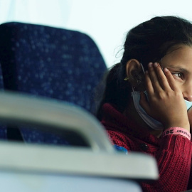 Una niña afgana, integrante de un grupo de ciudadanos evacuados de Kabul, permanece en un autobús tras su llegada al aeropuerto internacional Washington Dulles. EFE/ Will Oliver